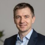 Улыбающийся российский бизнесмен в деловом стиле на размытом фоне для сайта займов студентам